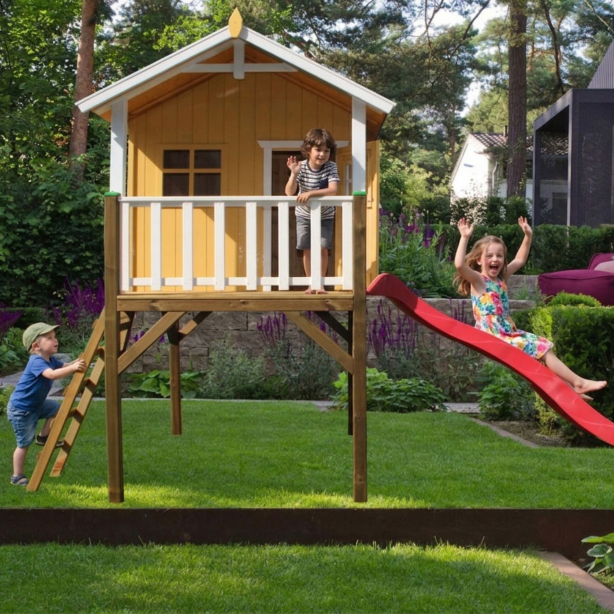 Gelbes KASO Stelzenhaus Jonas XL aus Holz auf Pfeilern im Garten mit drei spielenden Kindern auf der Treppe, Veranda und roten Rutsche.