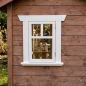 Preview: Weißes KASO Sprossen-Fenster FS3 eingebaut in einer braunen Holzfassade eines Kinderspielhauses