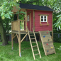 Preview: Schweden-Stelzenhaus aus Holz in Rot mit Leiter, Kletterwand und Balkon im grünen Garten.