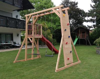 Spielturm Thor-1 aus Holz mit Kletterwand Schaukel und Rutsche
