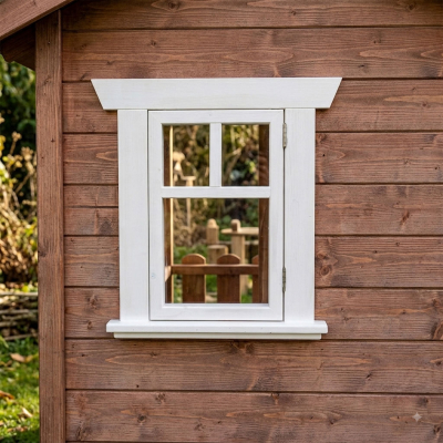 Weißes KASO Sprossen-Fenster FS3 eingebaut in einer braunen Holzfassade eines Kinderspielhauses