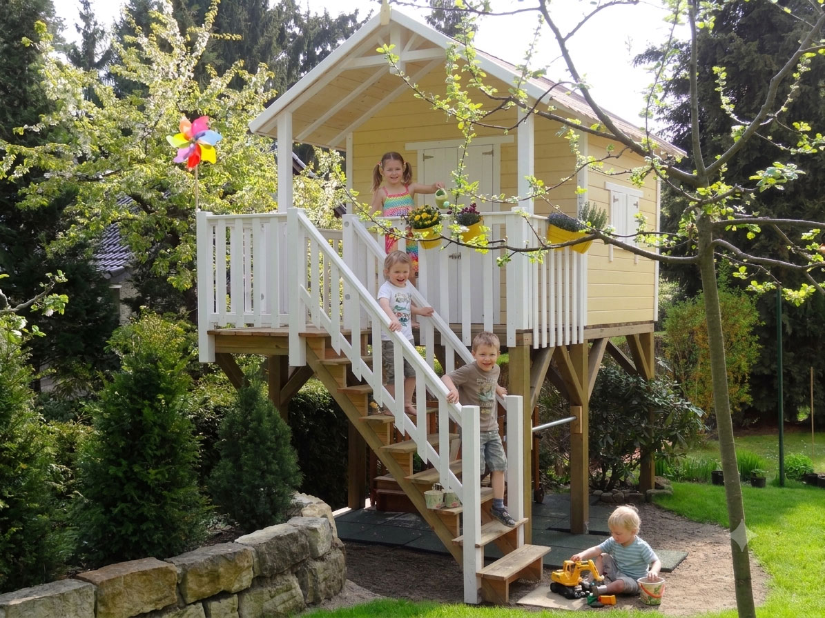 Spielende Kinder am Stelzenhaus Janson XXL-A1 Spielhaus mit Treppe im Garten
